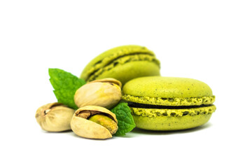 Sweet green pistachio flavor macaroons with nuts and leaves isolated on white background. Two...