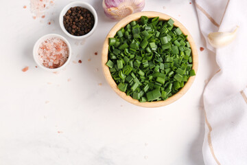 Bowl with slices of fresh green onion on white background