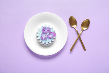 Plate of panna cotta with beautiful hydrangea flowers on lilac background
