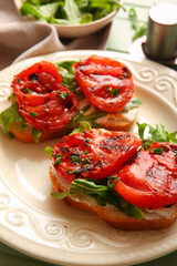 Plate of sandwiches with tasty grilled tomatoes and arugula, closeup