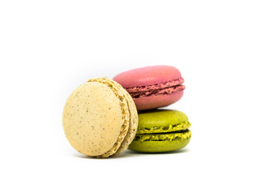 Three french multicolored macaroon on a white background. Green, pink and cream.