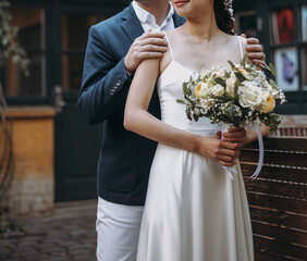 Groom wears blue suite and bride in white wedding dress. Bridal couple in love on a wedding day. - 615930820