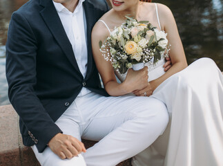 Groom wears blue suite and bride in white wedding dress. Bridal couple in love on a wedding day. - 615930868