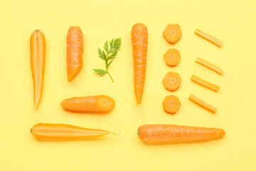 Fresh carrots and slices on yellow background