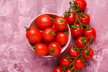 Bowl with fresh cherry tomatoes on purple background