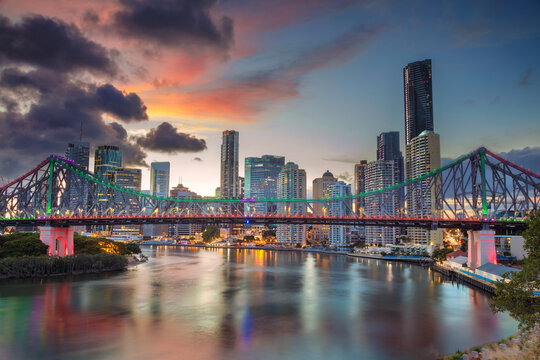 Cityscape image of Brisbane skyline, Australia with Story Bridge during dramatic sunset.