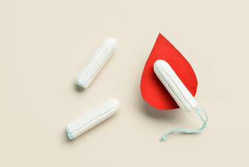 Composition with menstrual tampons and blood drop made of paper on light background