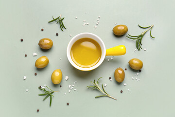 Bowl with fresh olive oil on green background
