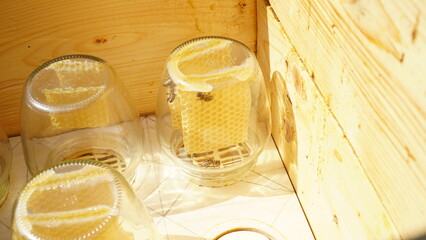Jar with honeycombs. Bees carry honey in a jar. A swarm of bees around a jar, in an apiary.