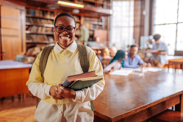 Joyful African American university student in library.