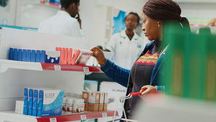 Client taking products off of pharmacy shelves, looking at medical drugs to buy prescription...