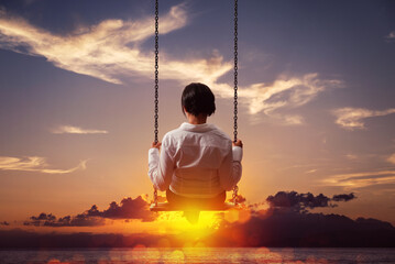 Business woman is swinging on a swing at sunset. Concept of serenity and relaxation