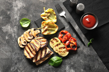 Boards with tasty grilled vegetables on grunge background