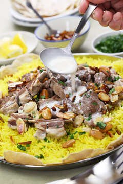 mansaf is a traditional Arab dish made of lamb cooked in a sauce of fermented dried yogurt and served with rice.