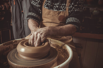 elderly man making pot using pottery wheel in studio. - obrazy, fototapety, plakaty