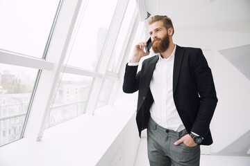 Businessman in a modern office talking to the mobile phone