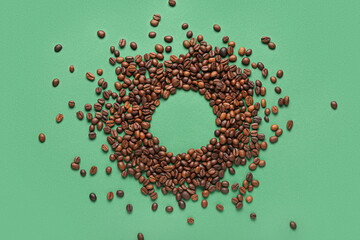 Frame made of coffee beans on green background