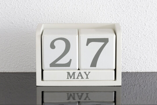 White block calendar present date 27 and month May on white wall background