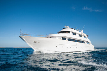 Fototapeta na wymiar A luxury private motor yacht under way on tropical sea with bow wave
