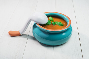fresh Pumpkin Soup in ceramic bowl with spoon on an old wooden background