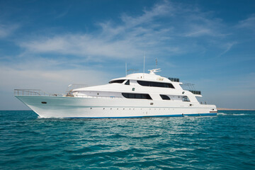 Obraz na płótnie Canvas A luxury private motor yacht under way on tropical sea with bow wave