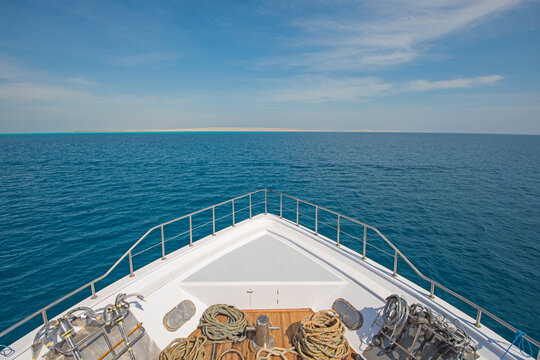 View over the bow of a large luxury motor yacht on tropical open ocean with anchors