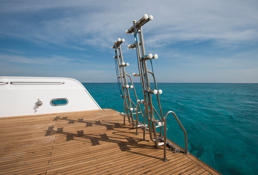 Metal steel ladders on back teak deck of a luxury motor yacht sailing on a tropical ocean