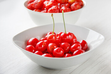 juicy fresh cherries in a white plate on a wooden table. selective focus. High quality photo