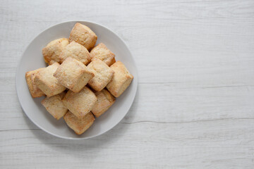 Fresh homemade biscuits on a plate lies on a wooden table view from above. selective focus