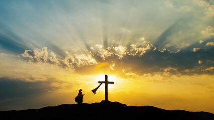 Silhouette of a woman praying at Holy Cross. Jesus Christ is alive.