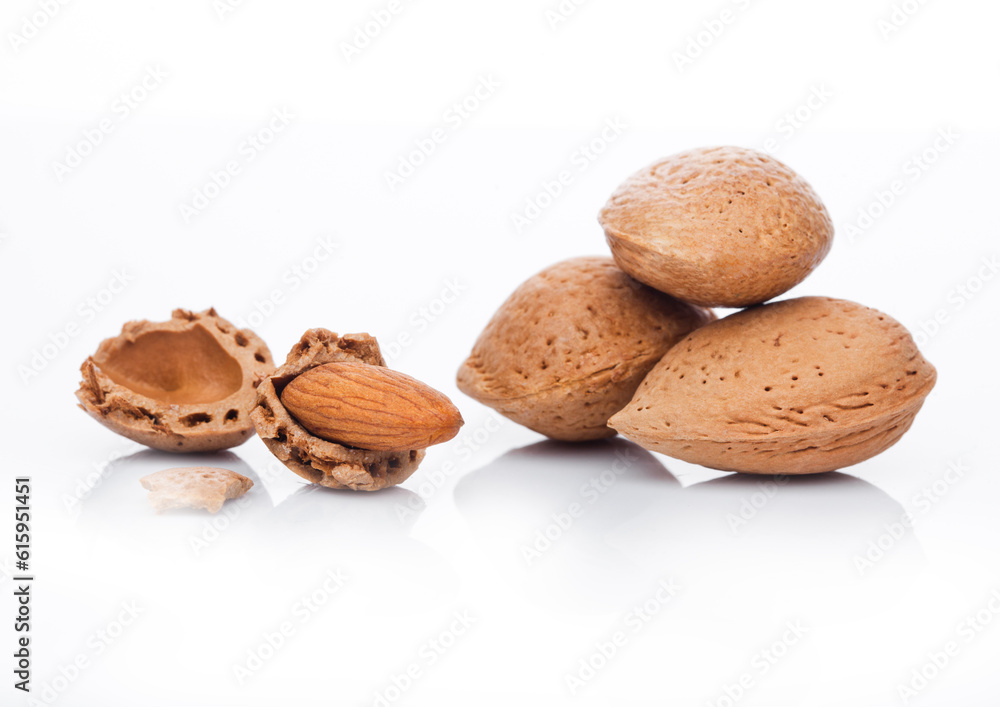 Poster raw almonds nuts with shell on white background with reflection
