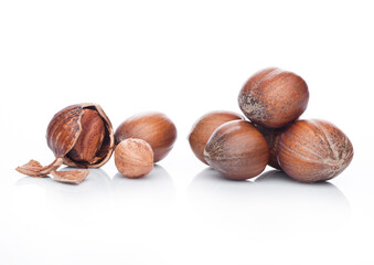 Raw hazelnuts with shell on white background with reflection