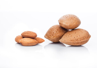Raw almonds nuts with shell on white background with reflection