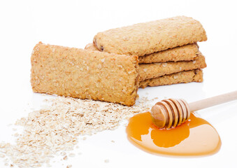 Fototapeta na wymiar Healthy bio breakfast grain biscuits with honey and raw oat porridge on white background