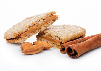 Healthy bio breakfast grain biscuits with almonds and cinnamon on white background