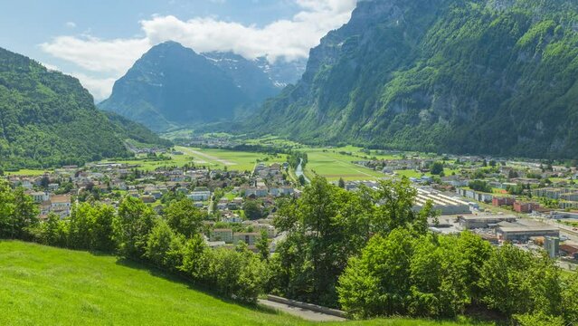 Timelapse, Panoramic view on town in mountains. Linth valley, Mollis, Glarus Nord, Canton of Glarus in Switzerland.