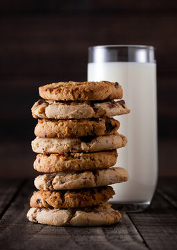 Sweet caramel and chocolate oatmeeal gluten free cookies on old wooden background with glass of milk