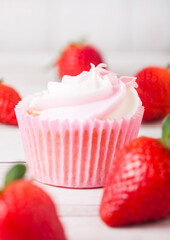 Cupcake muffin with strawberry cream dessert on wooden background with fresh strawberries