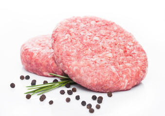 Raw fresh beef burgers with pepper and rosemarine on white background