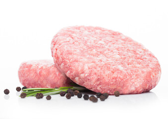 Raw fresh beef burgers with pepper and rosemarine on white background