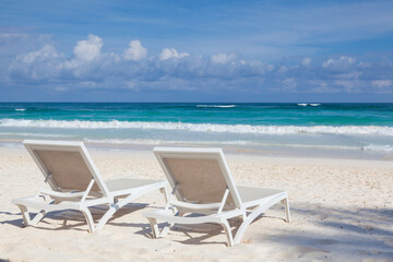 Two white beach chairs on the empty beach in Play del Carmen, Yucatan, Mexico