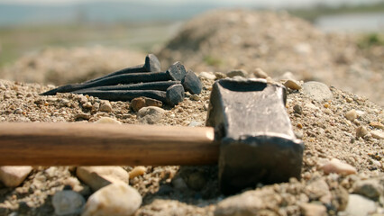 Hammer and nails placed on the ground for the crucifixion of Jesus. Focused detail - obrazy, fototapety, plakaty