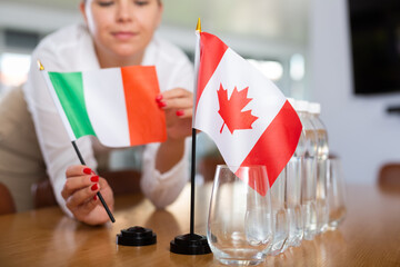 Little flag of Canada on table with bottles of water and flag of Italy put next to it by positive...