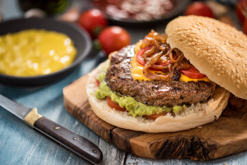 Tasty homemade burger served with different sauces top view