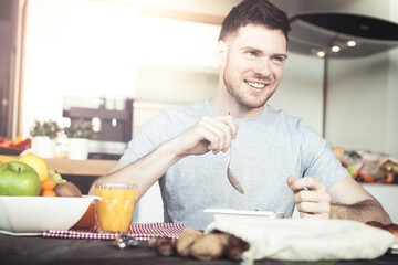 young man having a healthy breakfast in modern kitchen interior