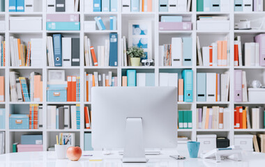 Professional creative contemporary workspace with computer on a desk and colorful folders on the background