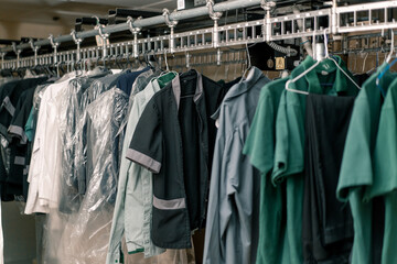 industrial laundry in the hotel clean shirts of employees and guests sorted after washing hang on...