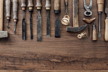 Set of vintage woodworking and carving tools on a rough workbench, blank copy space: carpentry,...