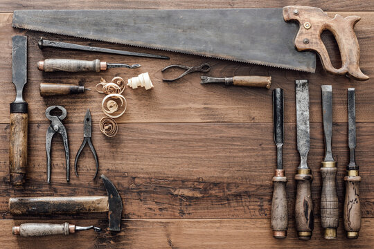 Frame composed of a collection of vintage woodworking tools on a workbench: carpentry, craftsmanship and handwork concept, flat lay