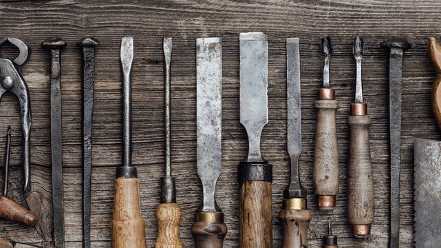 Collection of old woodworking and carving tools on a rough vintage table: carpentry, craftsmanship and handwork concept, flat lay